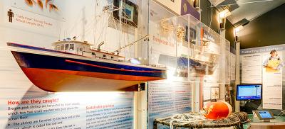 The sustainable fisheries exhibit. It shows a large model fishing boat, crab fishing gear, and informative text.