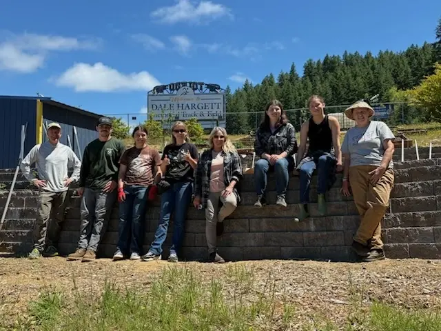 A group of people stand in front of a sign.