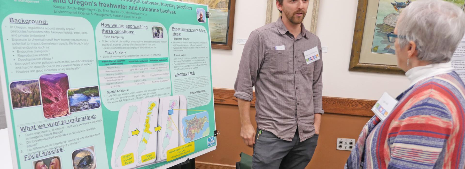 Student Kaegan Scully-Engelmeyer explains his research while standing in front of a poster