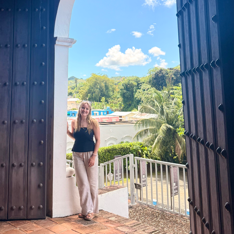 A person stands in a doorway and smiles.