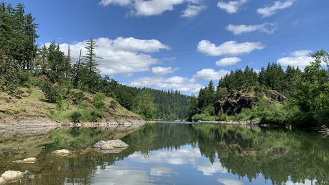 A rocky island on the Willamette River on a clear day.