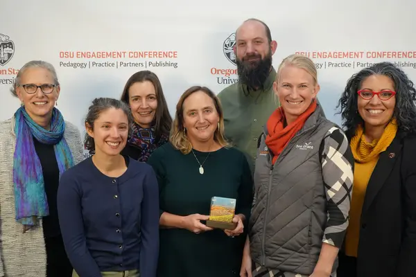 A group of people smile at the camera holding an award.